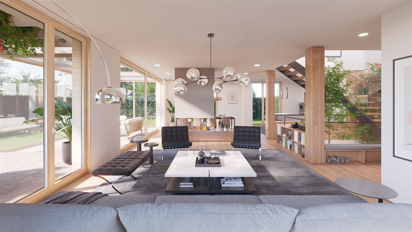 Salon traversant avec cheminée centrale et baies vitrées sur le jardin